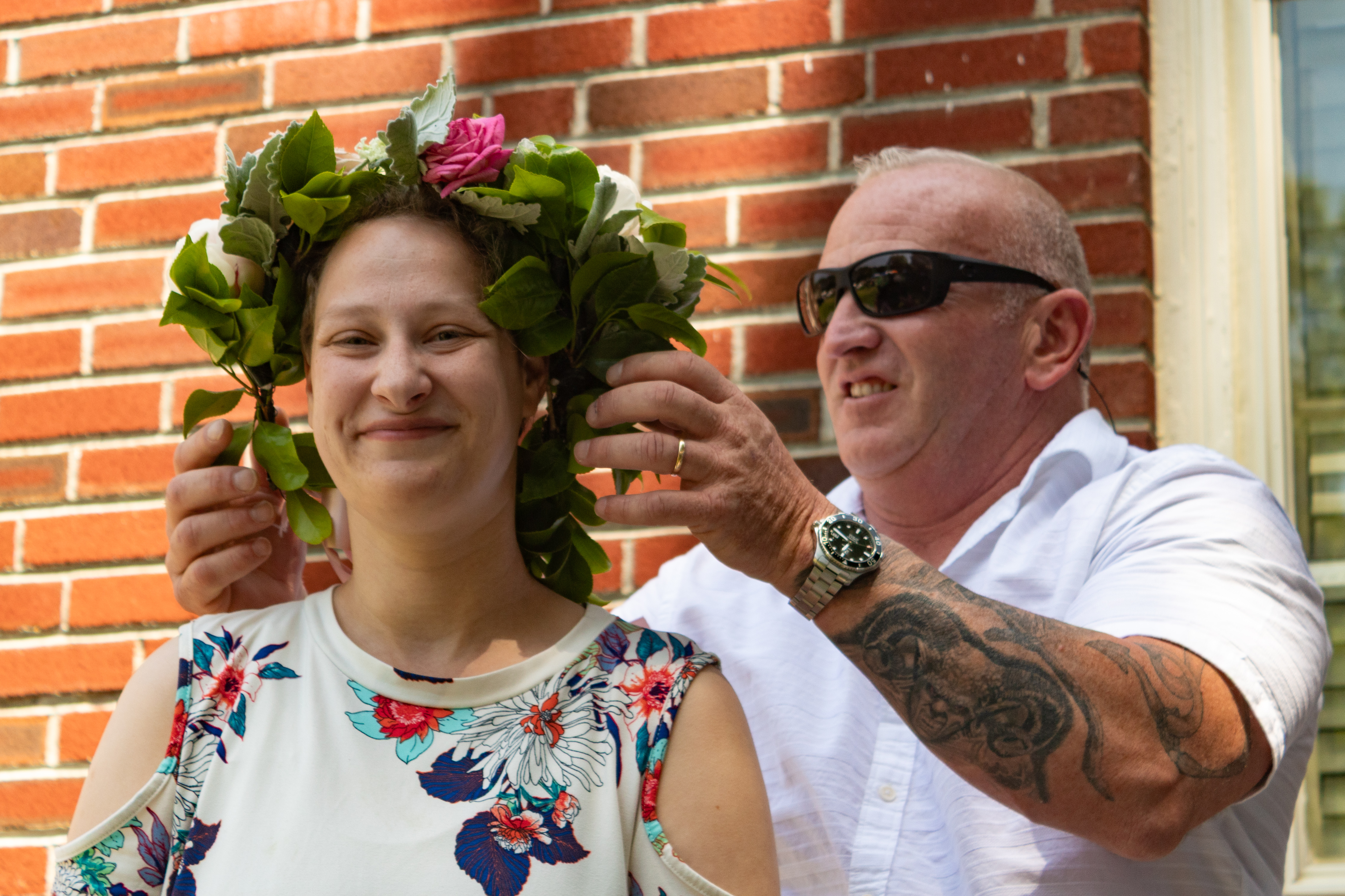 Flower crown being placed on a festival-goer at May Faire