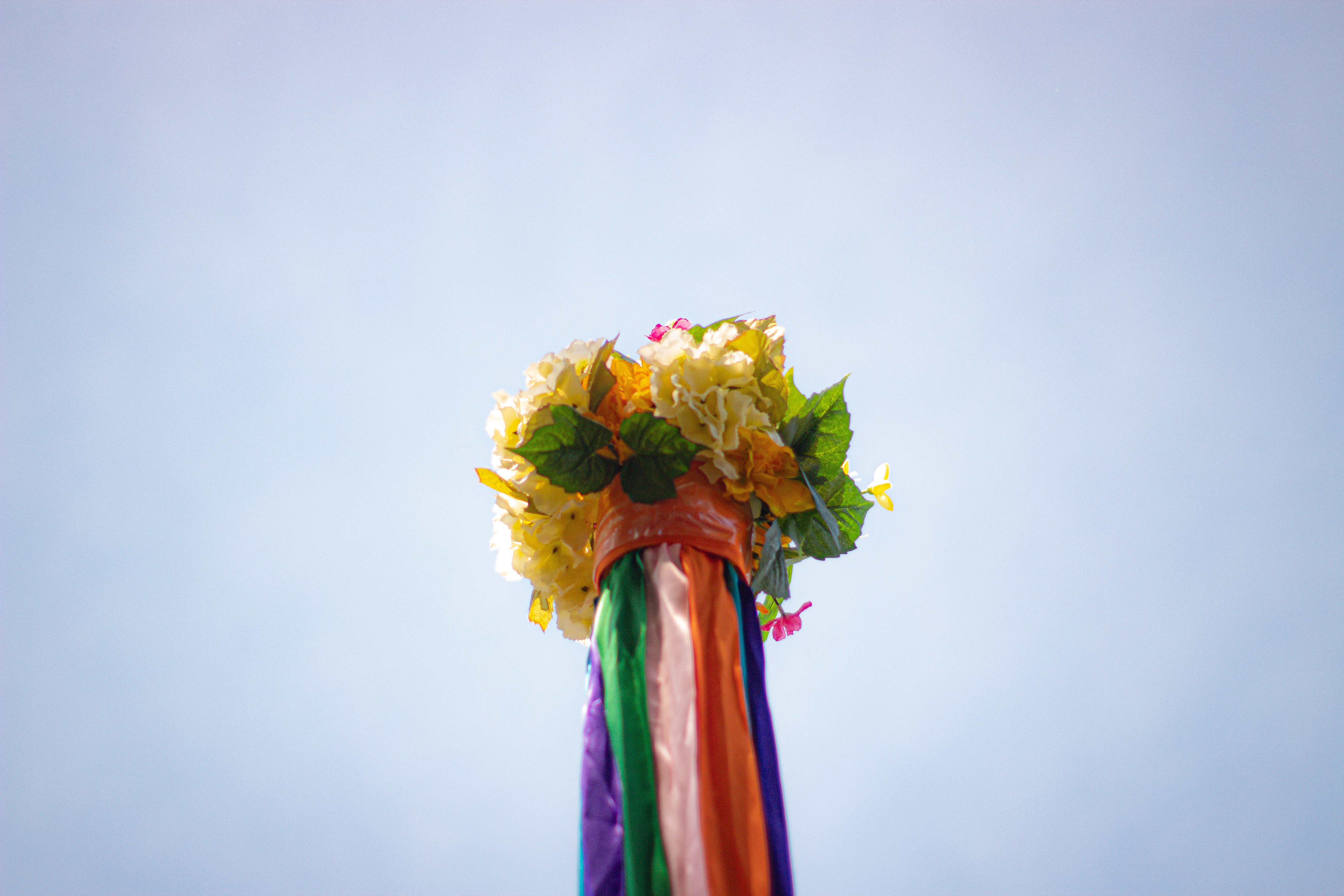 Floral arrangement at the top of the May pole against the sky