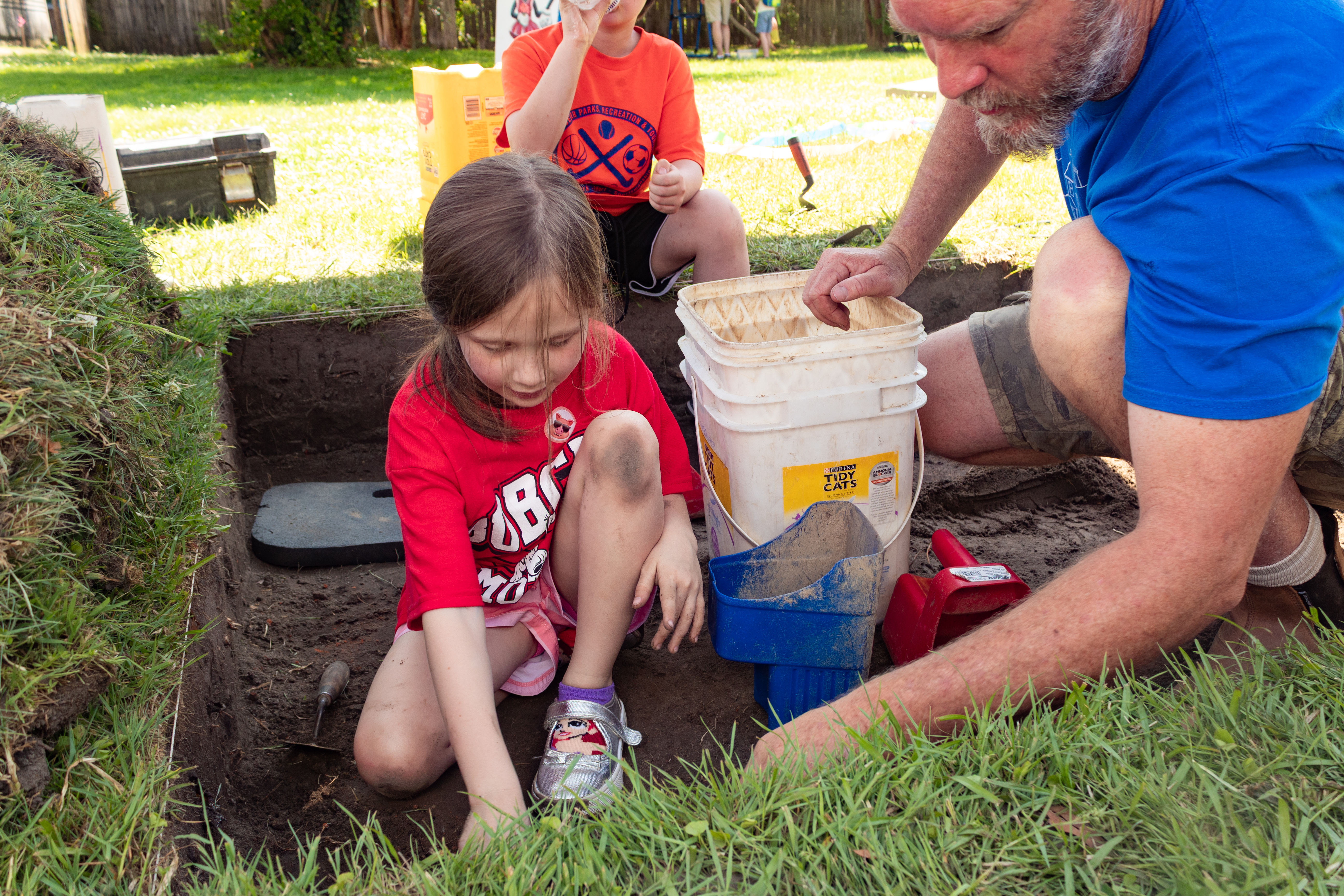 Child participating in a digging activity at May Faire